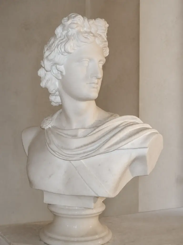 Busto di Apollo del Belvedere con volto giovane, capigliatura riccia e panneggio disposto sulle spalle