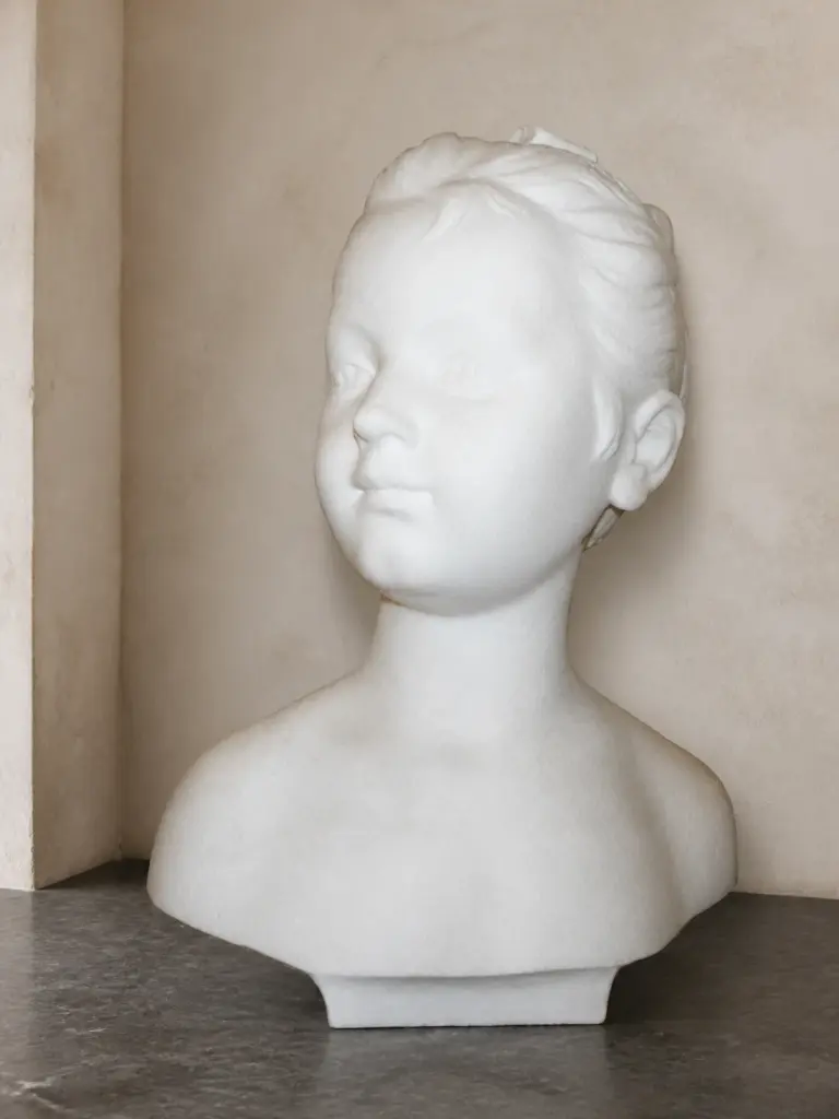 Il busto della bambina Brognart presenta un volto infantile dai lineamenti delicati e una forma essenziale delle spalle