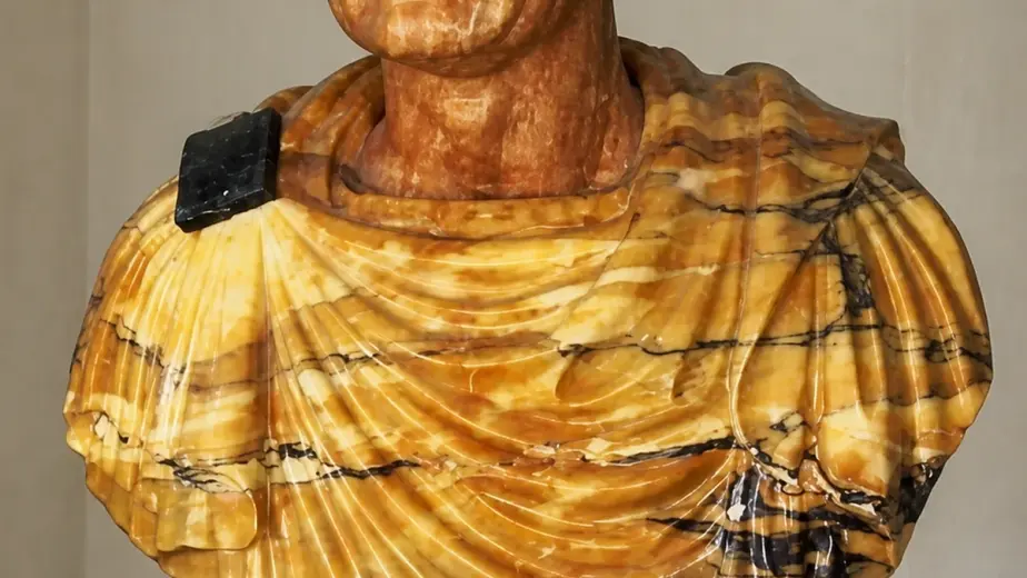 Il busto ritrae l'imperatore Vespasiano con capelli corti e veste drappeggiata