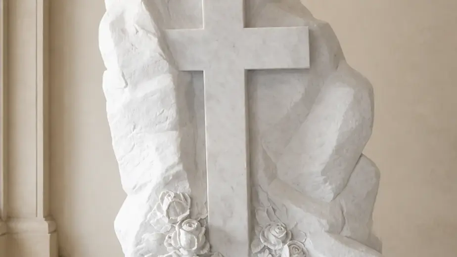 Cippo con croce e fiori in marmo, con croce in rilievo su roccia scolpita con rose alla base