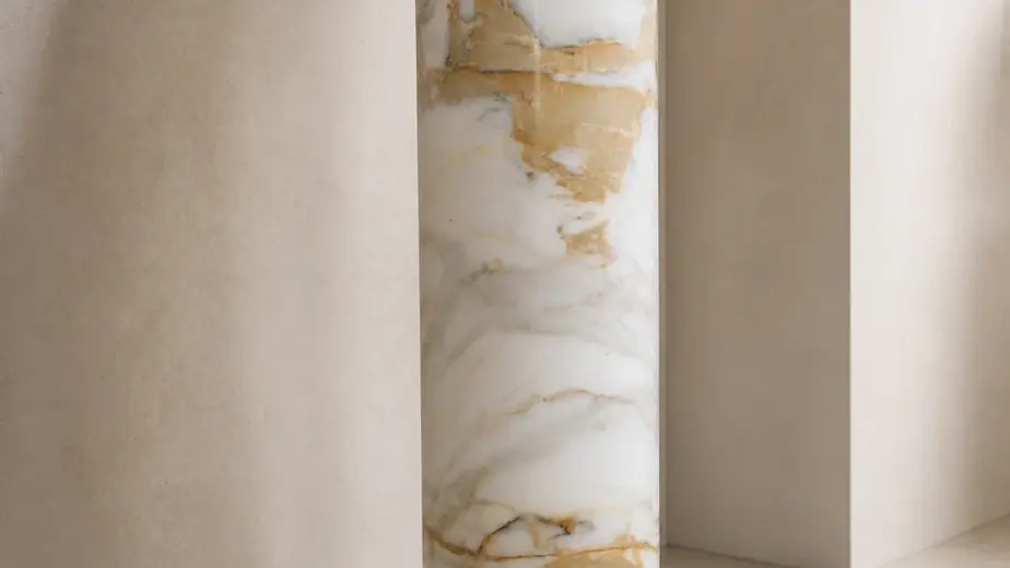 Colonna in marmo bianco calacatta lucidato, con fusto cilindrico dalle venature calde, base modanata e piano quadrato