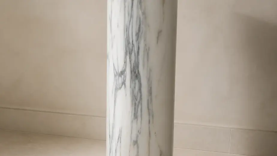 Colonna in marmo bianco statuario venato, con fusto cilindrico venato, base modanata e piano superiore quadrato