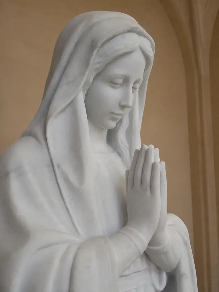 Madonna in preghiera in marmo bianco carrara, con figura velata con mani giunte e posa raccolta