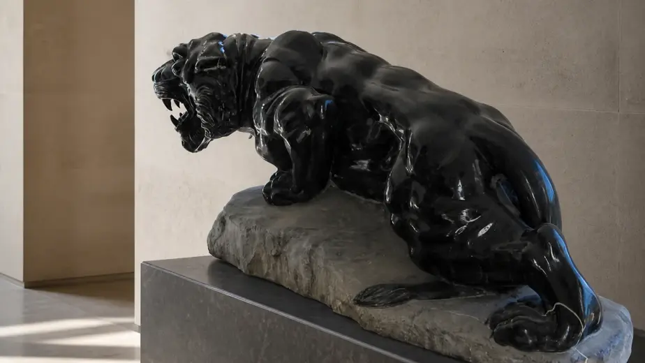 La scultura raffigura una pantera distesa ma tesa nel movimento, con zampe raccolte e testa vigile