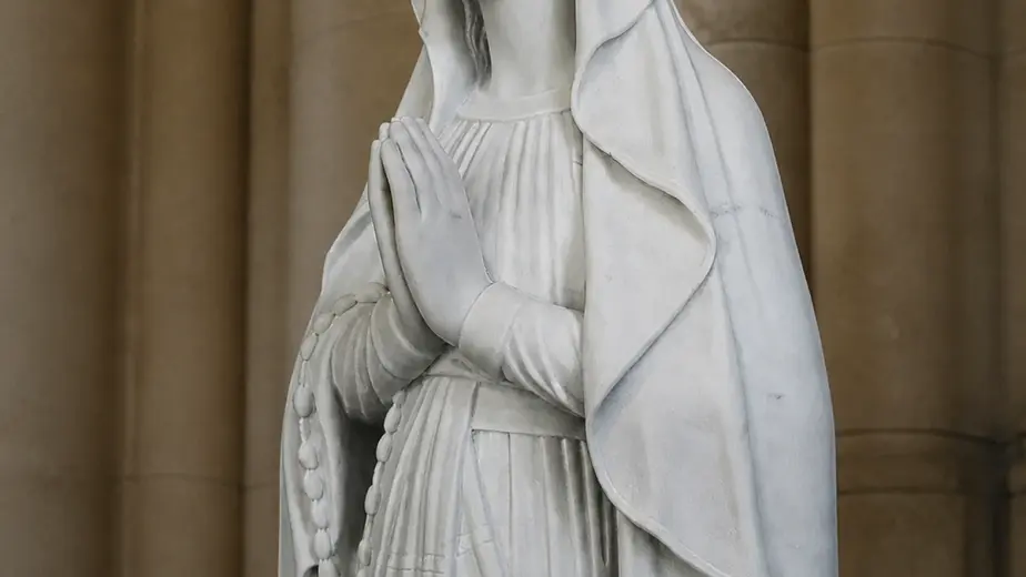 Madonna di lourdes in marmo bianco carrara, con figura intera con veste panneggiata e sguardo rivolto verso il basso