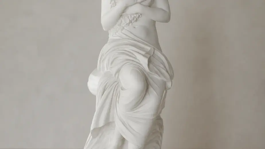 Venere seduta con fiori in marmo bianco, con figura femminile seduta che trattiene una decorazione floreale