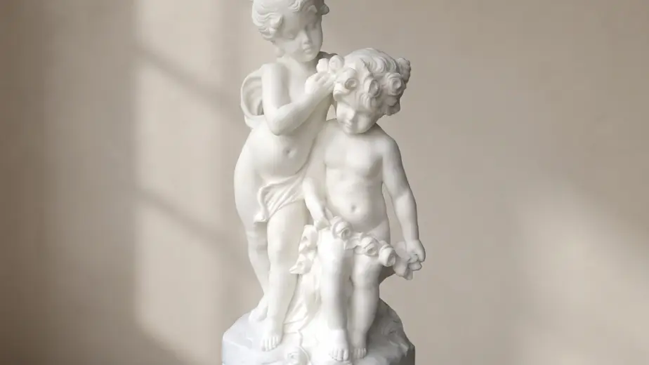 Gruppo scultoreo di bambine in marmo bianco, con due figure infantili con ghirlande di fiori su una base comune